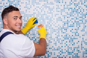 Worker cleaning grout from tile