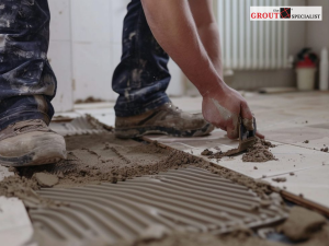 Professional performing Tile repair by replacing cracked floor tiles to restore durability and protect against damage caused by Colorado's changing climate.