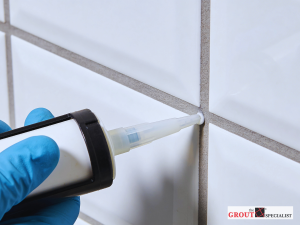 Professional applying grout sealing to tile joints, protecting surfaces from moisture, stains, and damage in residential flooring.